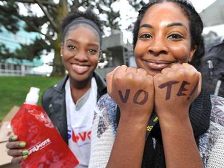 women with the words VOTE written on the back of her hands